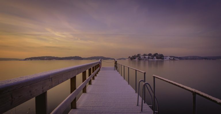Snöbeklädd brygga i soluppgång
